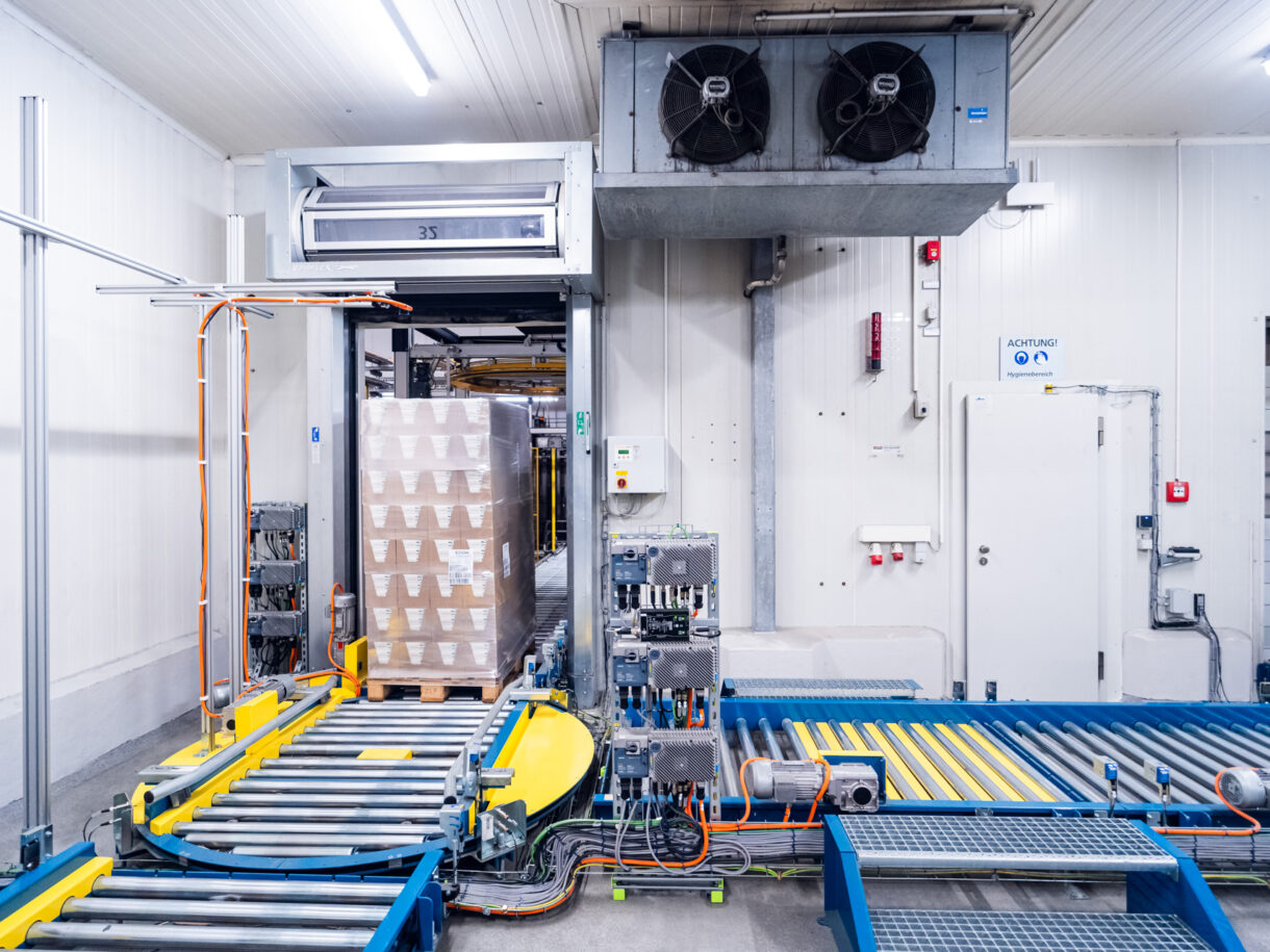 Eine Palette fährt über einen Palettenförderer auf einen Drehtisch