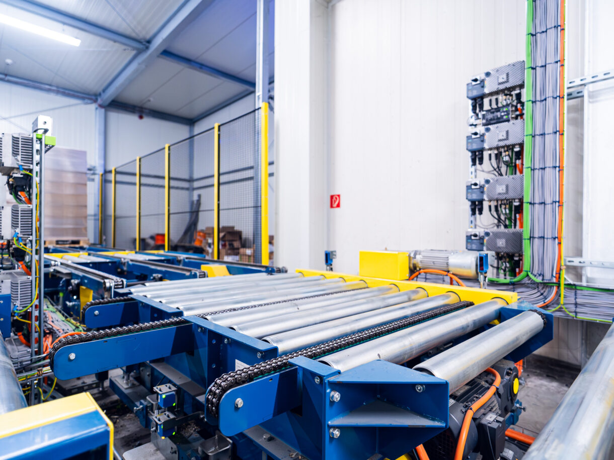 Blick auf einen Eckumsetzer für Paletten, der in ein Palettenfördersystem eingebunden ist